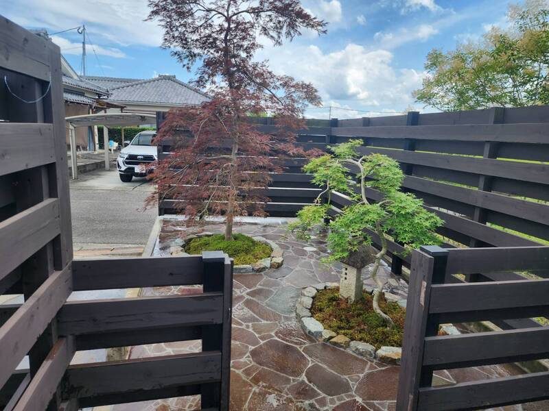 庭木と石張り、木塀を組み合わせた外構
